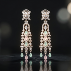 Pair of elegant earrings with gemstones on a reflective surface with blurred lights in the background