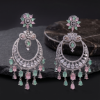 Pair of ornate earrings with gemstones on a dark surface