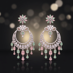 Pair of ornate earrings with gemstones on a dark background