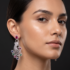 Close-up of a woman wearing a diamond earring with gemstones on a dark background