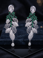 Pair of silver earrings with green gemstones on a dark background