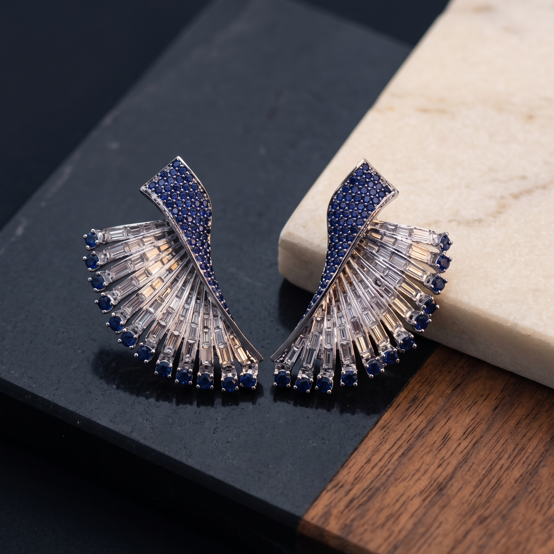 Elegant earrings with blue and clear gemstones on a dark surface