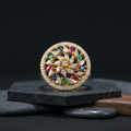 Decorative circular object with colorful gemstones on a dark background