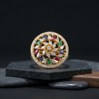 Decorative circular object with colorful gemstones on a dark background