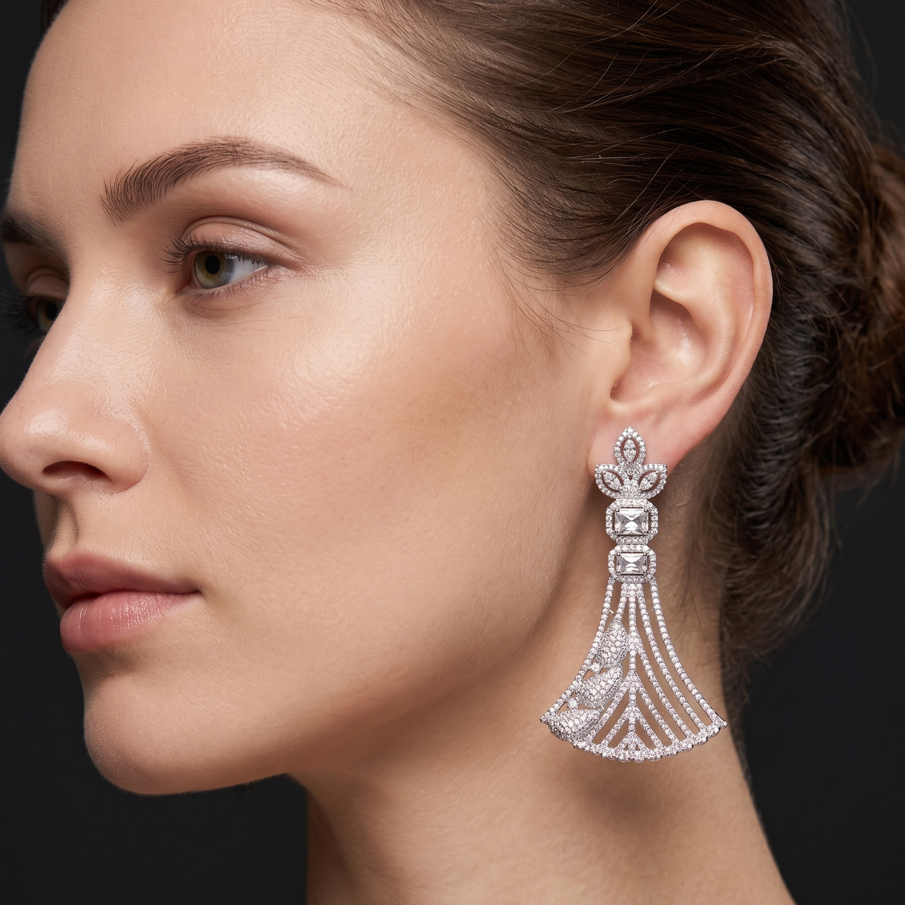 Close-up of a woman wearing a sparkling earring against a dark background