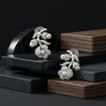 Pair of silver earrings with pearls on a dark surface