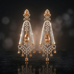 Pair of gold and diamond earrings on a dark background