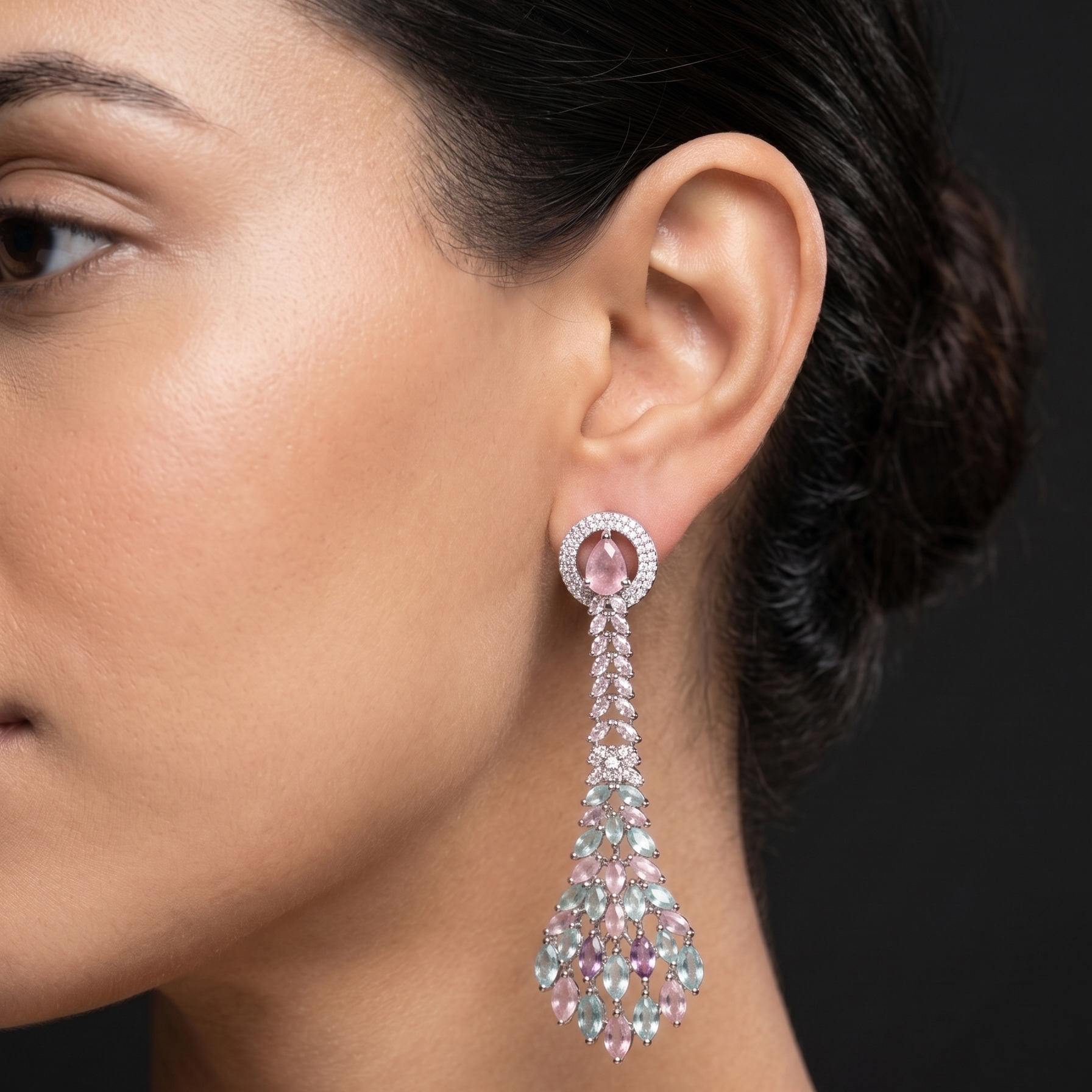 Close-up of a woman wearing a sparkling earring against a dark background