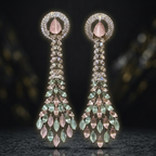 Pair of elegant earrings with gemstones on a reflective surface.