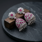 Pair of earrings with pink gemstones on a dark surface