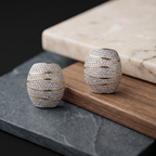 Pair of silver and gold earrings on a marble and slate surface