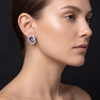 Woman wearing a pair of earrings against a dark background
