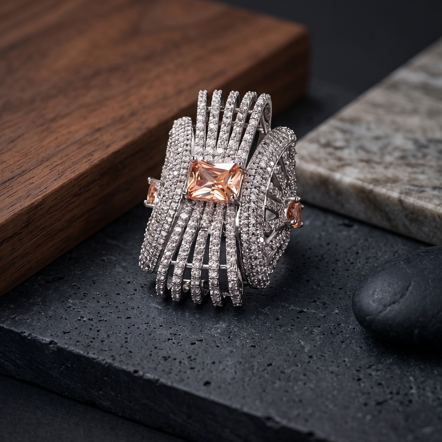 Silver ring with pink gemstones on a dark surface