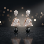 Pair of elegant earrings with black and gold details on a reflective surface with blurred lights in the background.