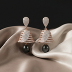 Pair of earrings with black stones on a beige fabric background