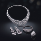 Silver jewelry set including necklace, earrings, bracelet, and ring on a dark background