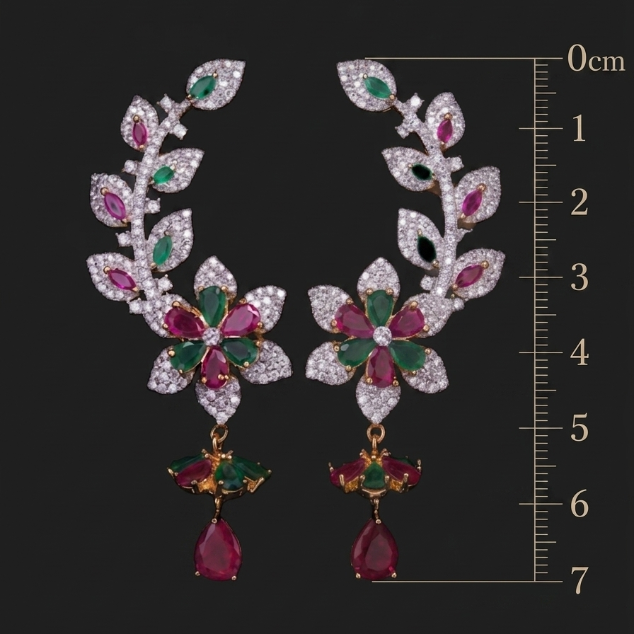 Ornate earrings with gemstones on a black background with a measurement scale.