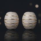 Pair of diamond earrings on a reflective surface with blurred lights in the background