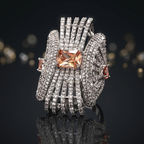 Elegant ring with a prominent gemstone on a reflective surface with blurred lights in the background