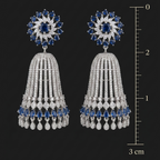 Pair of silver earrings with blue and clear gemstones, shown with a measurement scale on a black background.