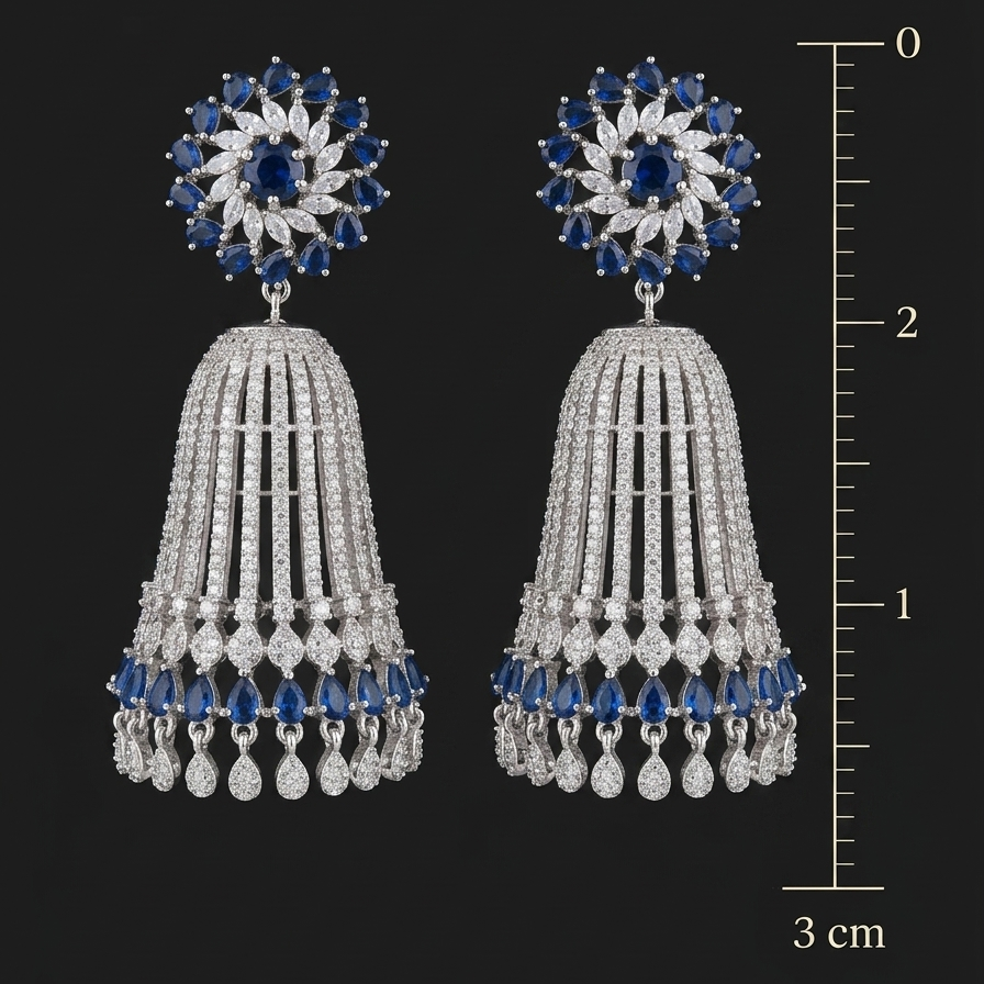 Pair of silver earrings with blue and clear gemstones, shown with a measurement scale on a black background.