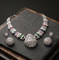Silver jewelry set with gemstones on a dark surface