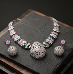 Silver jewelry set with gemstones on a dark surface