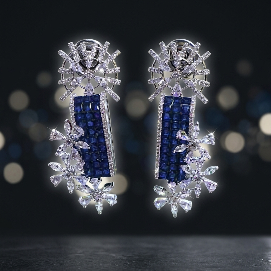 Pair of silver earrings with blue and clear gemstones on a dark background