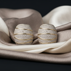 Pair of diamond earrings on a fabric surface