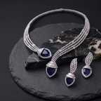 Jewelry set with necklace and earrings featuring blue gemstones on a dark surface