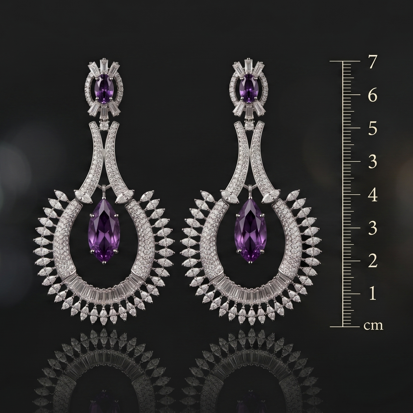 Pair of diamond and purple gemstone earrings with a ruler for scale on a dark background