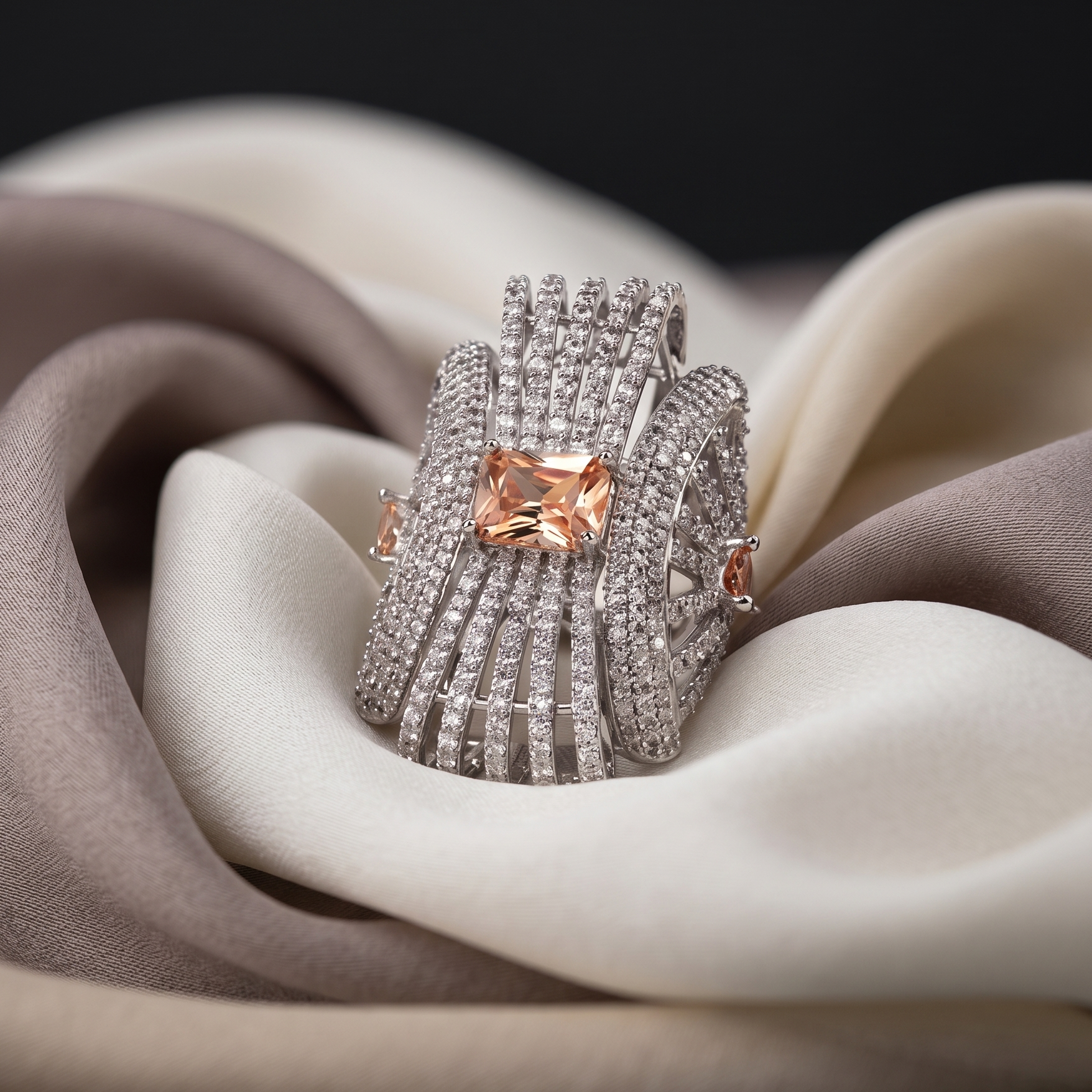 Silver ring with a pink gemstone on a soft fabric background