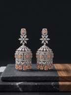 Pair of silver earrings with orange gemstones on a dark surface