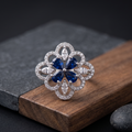 Silver ring with blue gemstone on a wooden block