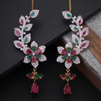 Pair of ornate earrings with gemstones on a dark surface