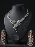 Silver necklace and earrings set on a black mannequin bust with 'Soreva' branding.