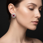 Close-up of a woman wearing a diamond earring with a red gemstone on a black background