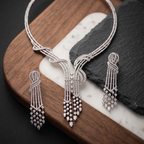 Silver necklace and earrings on a wooden and marble surface