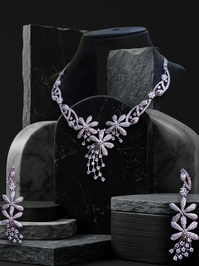 Delicate silver necklace and earrings on a dark stone surface