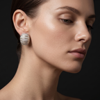 Close-up of a woman wearing silver earrings against a dark background