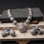 Silver jewelry set with gemstones on a stone surface