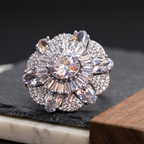 Elegant diamond ring on a dark stone surface with a wooden block