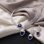 Jewelry set with necklace and earrings featuring blue gemstones on a beige fabric background