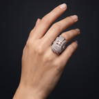 Hand wearing a decorative ring on a black background