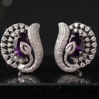 Pair of silver earrings with purple gemstones on a black background